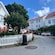 A quaint village street surrounded by buildings, trees and benches